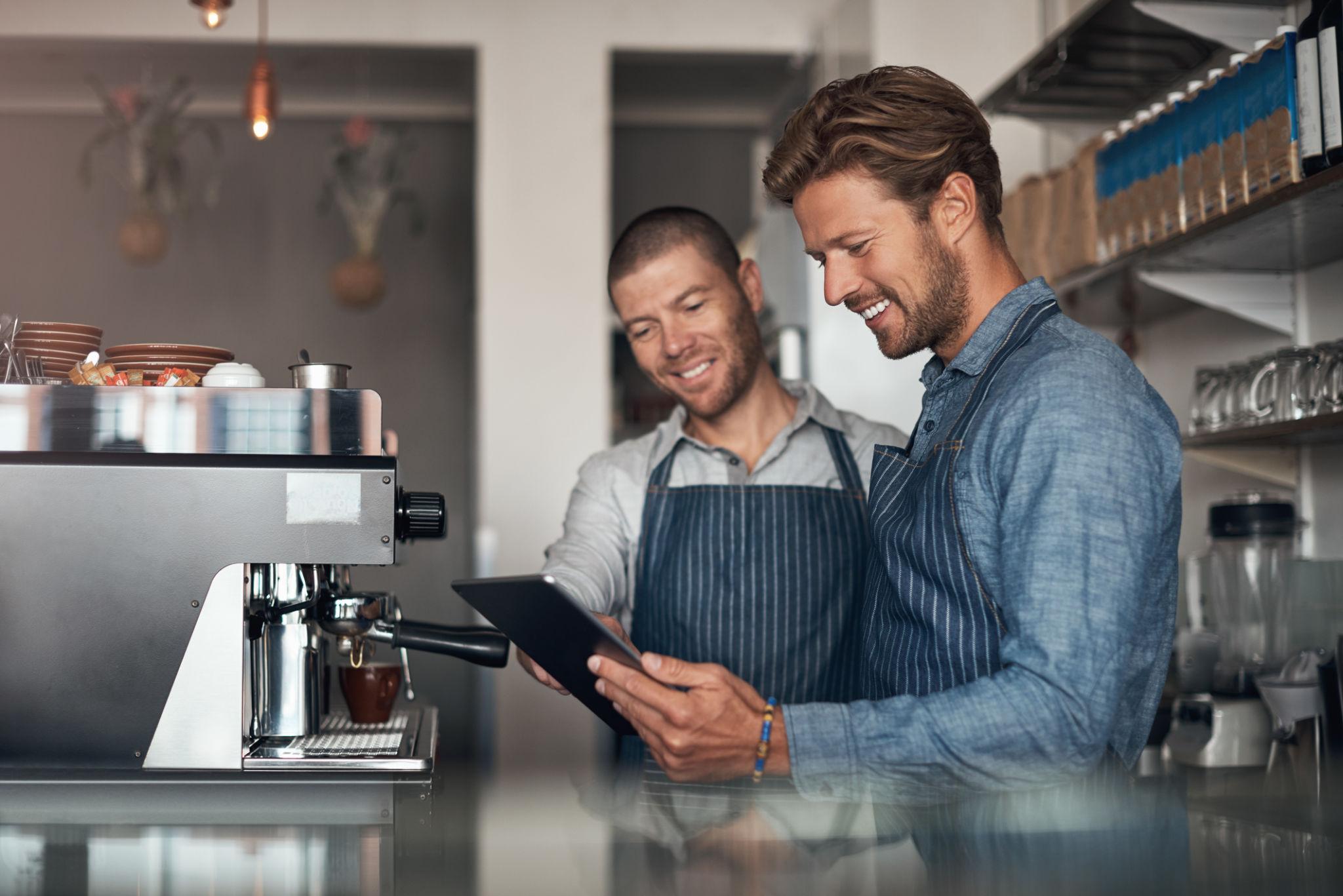 Food truck operators reviewing information on a tablet in a commercial kitchen